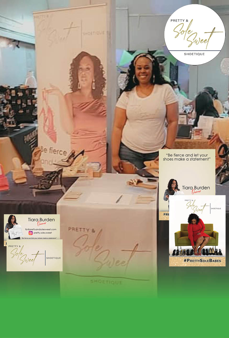 Business owner standing with her table setup at an event. Setup includes tall banner, table runner, pamphlets, business cards, custom logo